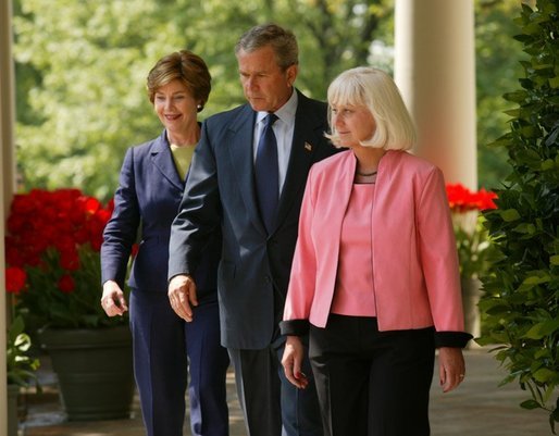 President George W. Bush and First Lady Mrs. Laura Bush walk down the colonnade with Kathleen Mellor of South Kingstown, Rhode Island before presenting her with the 2004 Teacher of the Year award in the Rose Garden of the White House on April 21, 2004. White House photo by Paul Morse.