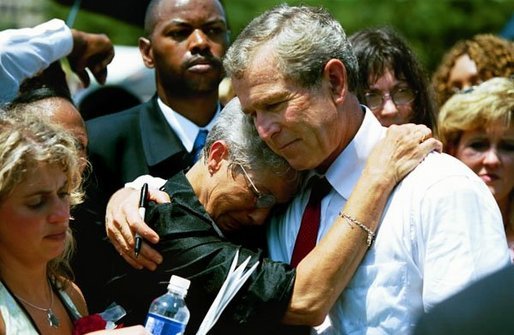 President George W. Bush hugs a woman attending the Annual Peace Officers' Memorial Service at the U.S. Capitol in Washington, D.C., Saturday, May 15, 2004. "I also thank all the family members who have come to Washington for this service. For each of you, there is a name on the National Law Enforcement Officers Memorial that will always stand apart. You feel the hurt of loss and separation, but I hope that you don't feel alone," said the President. White House photo by Paul Morse