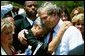 President George W. Bush hugs a woman attending the Annual Peace Officers' Memorial Service at the U.S. Capitol in Washington, D.C., Saturday, May 15, 2004. "I also thank all the family members who have come to Washington for this service. For each of you, there is a name on the National Law Enforcement Officers Memorial that will always stand apart. You feel the hurt of loss and separation, but I hope that you don't feel alone," said the President. White House photo by Paul Morse