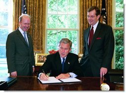 President George W. Bush signs the executive order establishing his Great Lakes Interagency Task Force, with EPA Administrator Michael Leavitt and James Connaughton, chairman of the Council on Environmental Quality, in the Oval Office Tuesday, May 18, 2004. The task force brings together ten agency and Cabinet officers to provide strategic direction on Federal Great Lakes policy, priorities and programs.  White House photo by Paul Morse