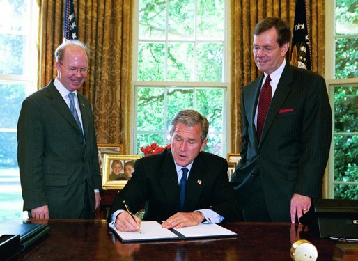 President George W. Bush signs the executive order establishing his Great Lakes Interagency Task Force, with EPA Administrator Michael Leavitt and James Connaughton, chairman of the Council on Environmental Quality, in the Oval Office Tuesday, May 18, 2004. The task force brings together ten agency and Cabinet officers to provide strategic direction on Federal Great Lakes policy, priorities and programs. White House photo by Paul Morse