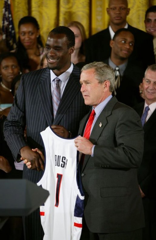 President George W. Bush stands with Emeka Okafor of the University of Connecticut's men basketball team during a ceremony in the East Room congratulating four NCAA teams for winning national titles Wednesday, May 19, 2004. White House photo by Paul Morse.