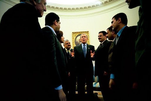 President George W. Bush talks with several Iraqis who receive medical care in the United States during a meeting in the Oval Office Tuesday, May 25, 2004. The Iraqi citizens each had one hand cut off in Iraq during Saddam's rule. "They are examples of the brutality of the tyrant," said President Bush. "These men had hands restored because of the generosity and love of an American citizen. And I am so proud to welcome them to the Oval Office." White House photo by Eric Draper