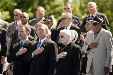 President George W. Bush sings the National Anthem with World War II veterans during the dedication of at the National World War II memorial on the Mall in Washington, DC on May 30, 2004. White House photo by Paul Morse