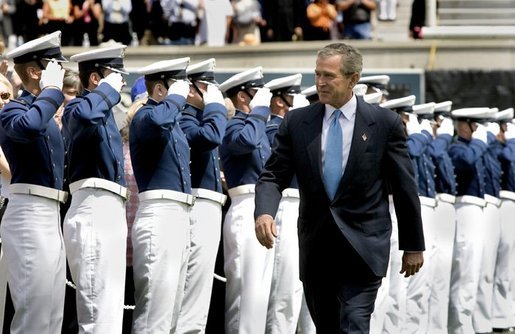 President George W. Bush walks to the stage while saluted by Air Force Cadets during his introduction at the United States Air Force Academy Graduation Ceremony in Colorado Springs, Colorado, June 2, 2004. White House photo by Eric Draper.