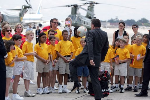 German Chancellor Gerhard Schroeder kicks a soccer ball with students during his arrival for the G8 Summit at Hunter Army Airfield in Savannah, Ga., June 8, 2004. White House photo by Paul Morse