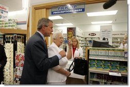 President George W. Bush helps senior Wanda Blackmore buy her prescriptions with her new drug discount card at the Hy-Vee pharmacy in Liberty, Mo., June 14, 2004.  White House photo by Paul Morse