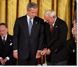 Recipient of the Presidential Medal of Freedom Arnold Palmer compares golf grips with President George W. Bush before receiving his award in the East Room of the White House on June 23, 2004.   White House photo by Paul Morse