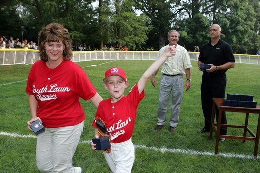 A player from the Challenger Phillies from Middletown, Delaware celebrates receiving a baseball from President George W. Bush and Cal Ripken Jr. at Tee Ball on the South Lawn at the White House on Sunday July 11, 2004. White House photo by Paul Morse.