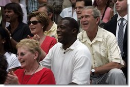 President George W. Bush and First Lady Laura Bush watch the Challenger Phillies of M.O.T. Little League from Middletown, Delaware take on the Challenger Yankees of Lancaster County Little Leagues from Lancaster County, Pennsylvania with former NFL Washington Redskins player Darrell Green, center, at Tee Ball on the South Lawn at the White House on Sunday July 11, 2004.  White House photo by Paul Morse