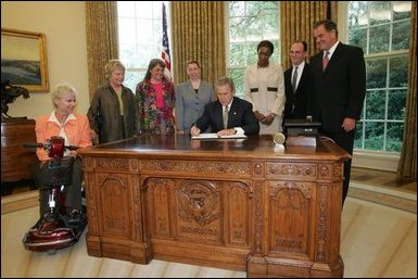 President George W. Bush signs an executive order for individuals with disabilities in emergency preparedness Thursday, July 22, 2004 in the Oval Office. White House photo by Eric Draper