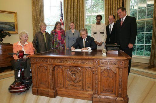 President George W. Bush signs an executive order for individuals with disabilities in emergency preparedness Thursday, July 22, 2004 in the Oval Office. White House photo by Eric Draper.
