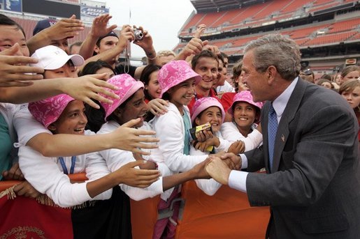 President George W. Bush is greeted by the Afghan girls soccer team after delivering remarks to the athletes at the International Children's Games and Cultural Festival in Cleveland, Ohio, July 30, 2004. White House photo by Paul Morse.