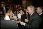 After delivering remarks and taking several questions, President George W. Bush greets audience members at the 2004 UNITY: Journalists of Color conference in Washington, D.C., Friday, Aug. 6, 2004.The convention is a nation-wide meeting of the National Association of Black Journalists, the National Association of Hispanic Journalists, the Asian American Journalists Association and the Native American Journalists Association. White House photo by Eric Draper.