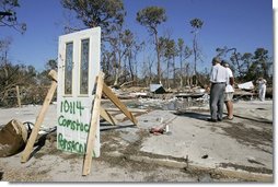 President George W. Bush stands with Al Boyd in the ruins of where Boyd's home used to be during a walking tour of neighborhoods damaged by Hurricane Ivan in Pensacola, Florida, Sunday, Sept. 19, 2004.  White House photo by Eric Draper