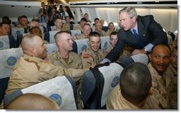 President George W. Bush greets members of two National Guard Units and an active Army unit headed to Iraq during a refueling stop in Bangor, Maine on September 23, 2004.  White House photo by Paul Morse