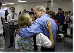 President George W. Bush shares a hug during a visit to Martin County Red Cross Headquarters in Stuart, Fla., Thursday, Sept. 30, 2004. "People in Florida and many other states are coming through a trying time," said the President in an address to the press. "I thank all those who've reached out to help the neighbors in need."  White House photo by Eric Draper
