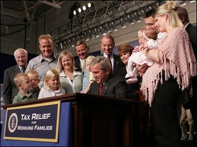 President George W. Bush signs H.R. 1308, the Working Families Tax Relief Act of 2004 at the South Suburban YMCA in Des Moines Iowa, Monday, Oct. 4, 2004