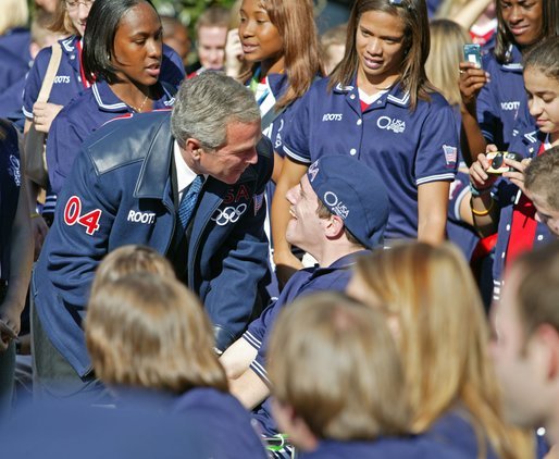 Wearing an Olympic jacket, President George W. Bush greets members of the 2004 U.S. Olympic and Paralympic Teams on the South Lawn Monday, Oct. 18, 2004. White House photo by Tina Hager