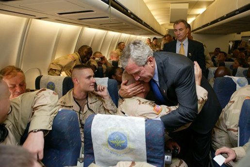 President Bush hugs a soldier during a stop at Bangor International Airport, Bangor, Maine, Sept. 23, 2004. Boarding their plane, the President met with members of 30th National Guard Brigade Combat Team, 230th National Guard Area Support Group, and 414th Army Transport Battalion. The troops stopped to refuel during along their way to Iraq. White House photo by Paul Morse.