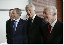 President George W. Bush, walks with, from left, former President George H.W. Bush, former President Bill Clinton, and former President Jimmy Carter during the dedication of the William J. Clinton Presidential Center and Park in Little Rock, Ark., Nov. 18, 2004.  White House photo by Eric Draper
