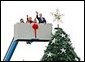 After placing a star on the National Christmas Tree, Lynne Cheney, wife of Vice President Dick Cheney, participates in the annual Pageant of Peace tree-topping tradition with Peter Nostrand, chairman of the Christmas Pageant of Peace program, right, and her three grandchildren (from left): Elizabeth Perry, 7, Grace Perry, 4, Kate Perry, 10, on the Ellipse near the White House Tuesday, Nov. 23, 2004. The 81st lighting of the famous tree takes place Dec. 2, 2004. White House photo by David Bohrer.