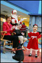 Mrs. Bush and Taylor Buckles, older sister of conjoined twins successfully separated earlier this year, react to the first viewing of the 2004 BarneyCam during a children's holiday program at the Children's National Medical Center in Washington, D.C., Wednesday, Dec., 15, 2004. White House photo by Susan Sterner