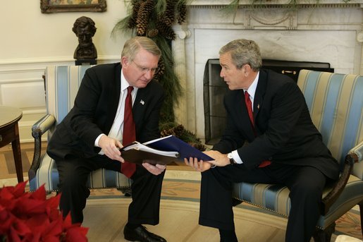 President George W. Bush receives the results of the 2004 Monitoring the Future study from Director John Walters of the Office of National Drug Control Policy in the Oval Office Tuesday, Dec. 21, 2004. The study measures drug, alcohol and cigarette use among adolescent students nationwide. This year's report found that drug use among teens has declined 17 percent since 2001. White House photo by Paul Morse