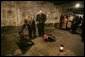 Vice President Dick Cheney and his daughter Liz Cheney, left, along with other members of a U.S. delegation, lay flowers at a memorial inside the first gas chamber at the Auschwitz-1 Nazi concentration camp, near Krakow, Poland, Jan. 28, 2005. Vice President Cheney was there to take part in ceremonies commemorating the 60th Anniversary of the liberation of the Auschwitz camps. The Wall of Death was named for its use as the backdrop for firing squads where thousands of prisoners were executed while the camp was in operation. White House photo by David Bohrer