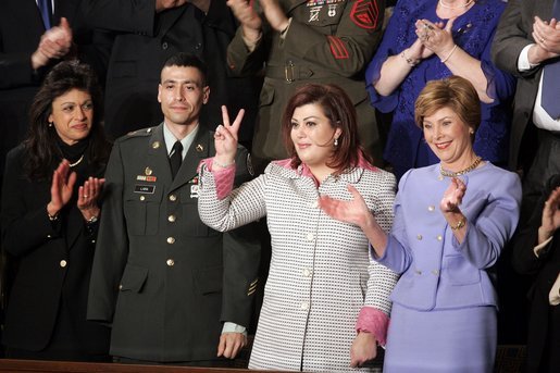 Safia Taleb al-Suhail, leader of the Iraqi Women's Political Council, second on right, displays a peace sign as other guests applaud during President George W. Bush's State of the Union speech at the U.S. Capitol, Wednesday, Feb. 2, 2005. Also pictured are, from left, Kindergarten teacher Lorna Clark of Santa Theresa, New Mexico, Army Staff Sergeant Norbert Lara, and Laura Bush. White House photo by Paul Morse