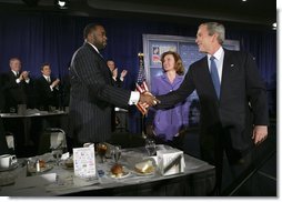 President George W. Bush greets Detroit Mayor Kwame Kilpatrick after delivering remarks at the Detroit Economic Club in Detroit, Michigan, Tuesday, Feb. 8, 2005. Also pictured at center is Detroit Economic Club President Beth Chappell.   White House photo by Eric Draper