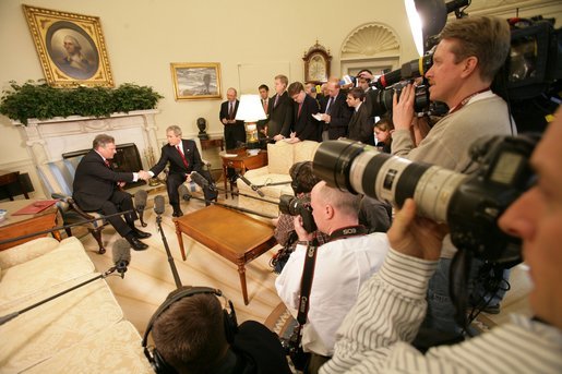 Surrounded by the members of the media, President George W. Bush greets Poland's President Aleksander Kwasniewski in the Oval Office Wednesday, Feb. 9, 2005. White House photo by Eric Draper