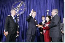 As President George W. Bush looks on, Mike Leavitt is sworn into office as Secretary of Health and Human Services by Chief of Staff Andrew Card. With Mr. Leavitt are his wife, Jackie, and son, Westin. The ceremony took place in the Great Hall at the U.S. Department of Health and Human Services.  White House photo by Paul Morse