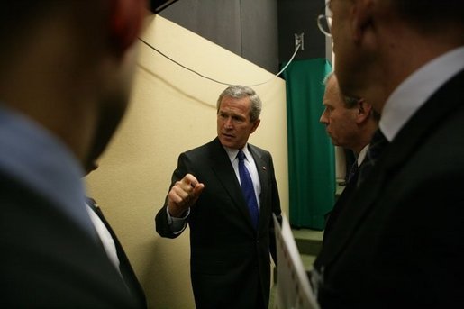 President George W. Bush speaks with his staff before a Feb. 22, 2005 joint news conference with NATO Secretary General Jaap de Hoop Scheffer at NATO headquarters in Brussels. White House photo by Eric Draper