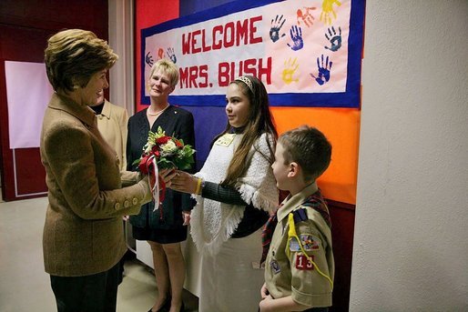 Hainerberg elementary students Montana Feix and Matt Bowlsby greet Laura Bush as she arrives to the school Tuesday, Feb. 22, 2005, in Wiesbaden, Germany. During her visit to the school Mrs. Bush heard a recital by the school chorus and talked with a group of fourth and fifth graders. White House photo by Susan Sterner
