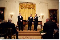 President George W. Bush thanks composer Marvin Hamlisch, left, and entertainer Mark McVey for their performance during the state dinner for the National Governors Association at the White House Sunday, Feb. 27, 2005.  White House photo by Paul Morse