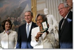 Rachel Robinson accepts the Congressional Gold Medal on behalf of her husband Jackie Robinson during a ceremony at the U.S. Capitol, Wednesday, March 2, 2005. Pictured, from left, are Congressional Minority Leader Nancy Pelosi, President George W. Bush, Rachel Robinson and Speaker of the House Dennis Hastert.  White House photo by Eric Draper