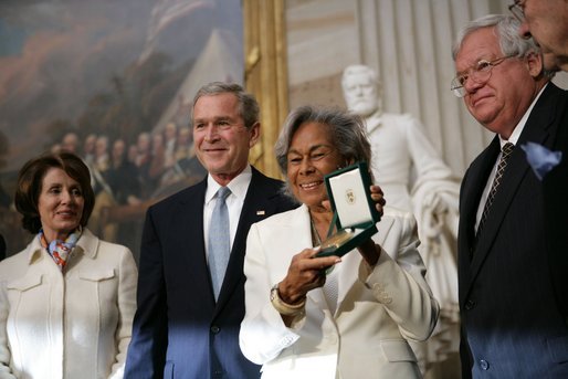 Rachel Robinson accepts the Congressional Gold Medal on behalf of her husband Jackie Robinson during a ceremony at the U.S. Capitol, Wednesday, March 2, 2005. Pictured, from left, are Congressional Minority Leader Nancy Pelosi, President George W. Bush, Rachel Robinson and Speaker of the House Dennis Hastert. White House photo by Eric Draper