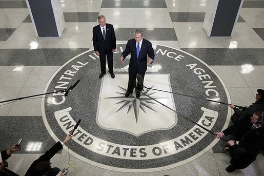 Standing on the agency seal, President George W. Bush speaks to the media inside the CIA headquarters Thursday, March 3, 2005, as CIA Director Porter Goss listens in. White House photo by Paul Morse