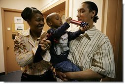 Kevion Thigpen, 3, held by his parents Kanyatta "Ken" Thigpen and his girlfriend Jewell Reed plays with a kaleidescope given to him by Laura Bush during a visit to the Rosalie Manor Community and Family Services center in Milwaukee, Wis., Tuesday, March 8, 2005. Citing a New York Times article by Jason DeParle Mrs. Bush credits Mr. Thigpen's determination to be a responsible father with bringing her attention to the needs of boys and young men.  White House photo by Susan Sterner