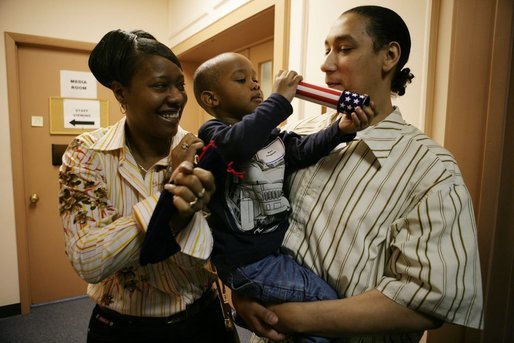 Kevion Thigpen, 3, held by his parents Kanyatta "Ken" Thigpen and his girlfriend Jewell Reed plays with a kaleidescope given to him by Laura Bush during a visit to the Rosalie Manor Community and Family Services center in Milwaukee, Wis., Tuesday, March 8, 2005. Citing a New York Times article by Jason DeParle Mrs. Bush credits Mr. Thigpen's determination to be a responsible father with bringing her attention to the needs of boys and young men. White House photo by Susan Sterner