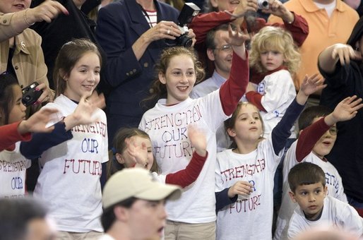 Wearing matching T-shirts, a group of future retirees wave during the President's visit to Shreveport, La., Friday, March 11, 2005. White House photo by Paul Morse
