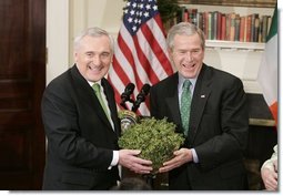 President George W. Bush accepts a bowl of shamrocks from Irish Prime Minister Bertie Ahern during a ceremony celebrating St. Patrick's Day in the Roosevelt Room Thursday, March 17, 2005.  White House photo by Paul Morse