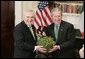 President George W. Bush accepts a bowl of shamrocks from Irish Prime Minister Bertie Ahern during a ceremony celebrating St. Patrick's Day in the Roosevelt Room Thursday, March 17, 2005. White House photo by Paul Morse