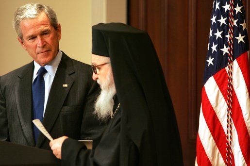 President George W. Bush listens as Archbishop Demetrios Trakatellis delivers brief remarks Monday, March 28, 2005, during a celebration of Greek Independence Day at the Eisenhower Executive Office Building in Washington DC.White House photo by Krisanne Johnson