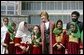 Mrs. Laura Bush stands with a group of Afghan girls on hand to greet her Wednesday, March 30, 2005, upon her arrival in Kabul. White House photo by Susan Sterner