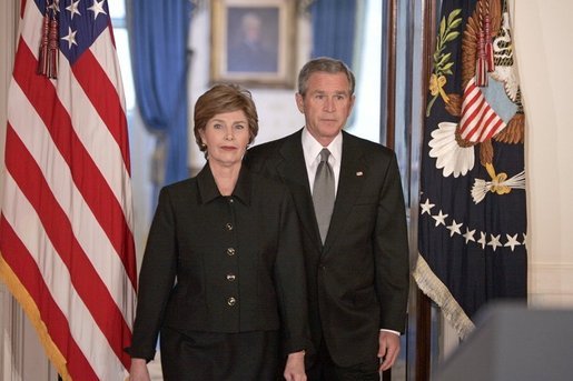 President George W. Bush and Mrs. Laura Bush walk into the Cross Hall prior to the President giving remarks on the death of Pope John Paul II at the White House on Saturday April 2, 2005. White House photo by Paul Morse