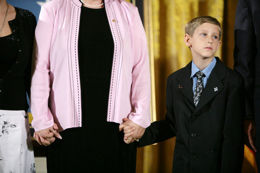 Eleven-year-old David Smith looks solemnly towards the audience as he and his step-sister Jessica, left, hold their mom's hands during ceremonies Monday, April 4, 2005, at the White House. David's father, Sgt. 1st Class Paul Smith, was honored posthumously by President Bush with the Medal of Honor, the first presented for service in support of Operation Iraqi Freedom.White House photo by Eric Draper