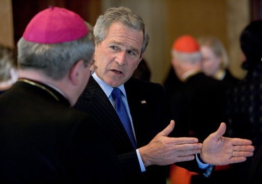 President George W. Bush gestures as he talks with Justin Cardinal Rigali, Archbishop of Philadelphia, during a reception Thursday, April 7, 2005, in Rome. The gathering at the home of the U.S. Ambassador to Italy was attended by American Cardinals, Archbishops and Bishops of the Catholic Church, on hand for Friday's funeral of Pope John Paul II. White House photo by Eric Draper