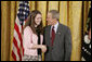 President George W. Bush congratulates Megan Larcom, 16, of Middletown High School in Middletown, R.I., on receiving the President’s Environmental Youth Award in the East Room of the White House April 21, 2005. White House photo by Paul Morse